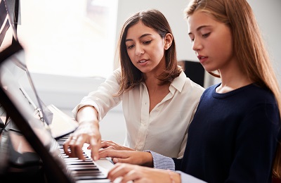 piano teacher and student
        sitting at a piano